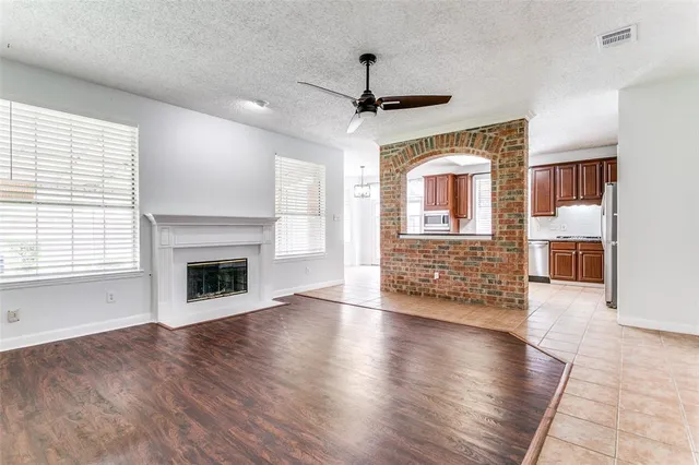a view of a livingroom with wooden floor a fireplace and windows