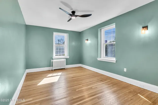a view of a livingroom with a ceiling fan and windows