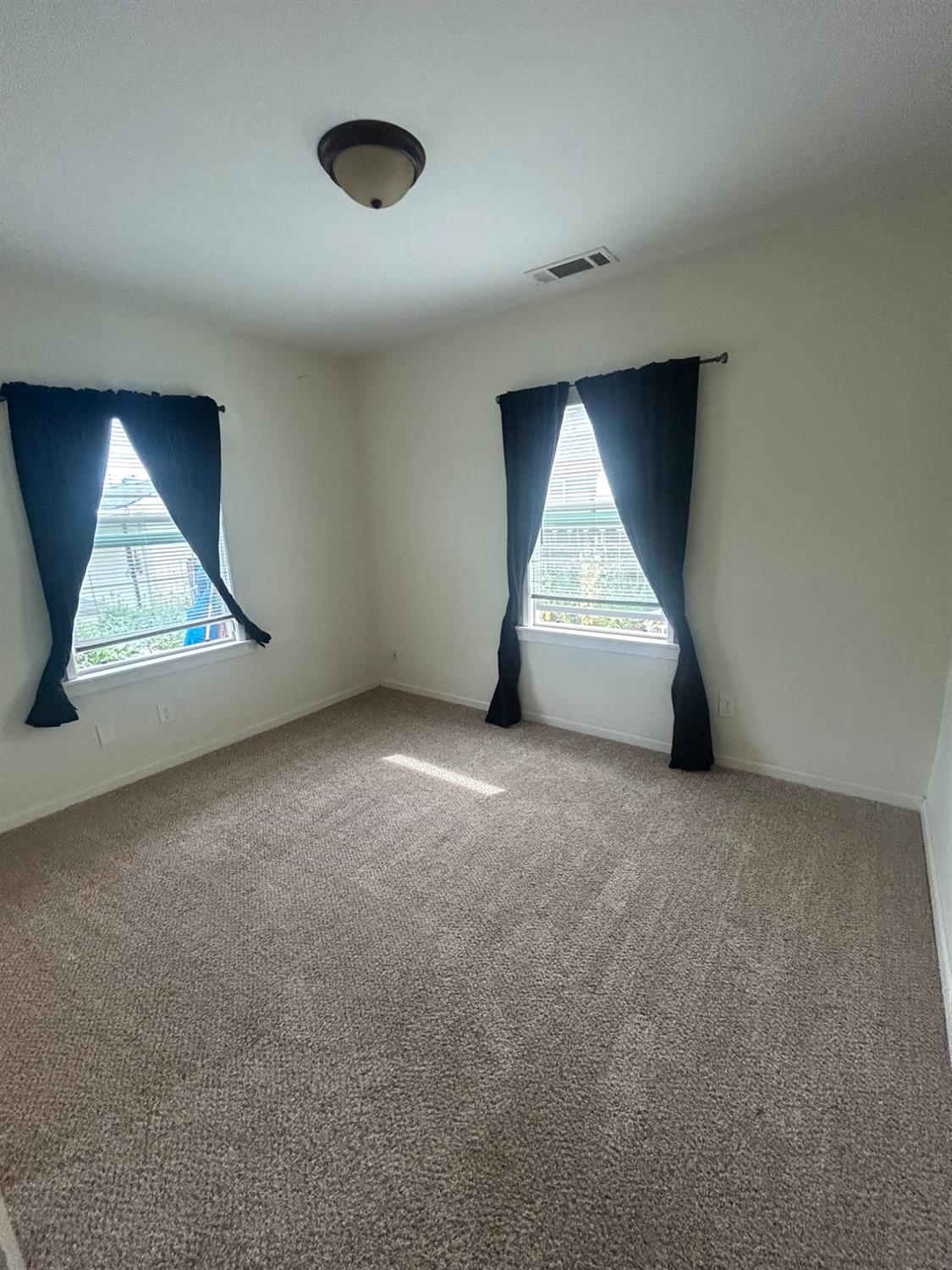 313 East Sacramento Street Coalinga, CA 93210 - Photo 8 of 23 an empty room with wooden floor and windows