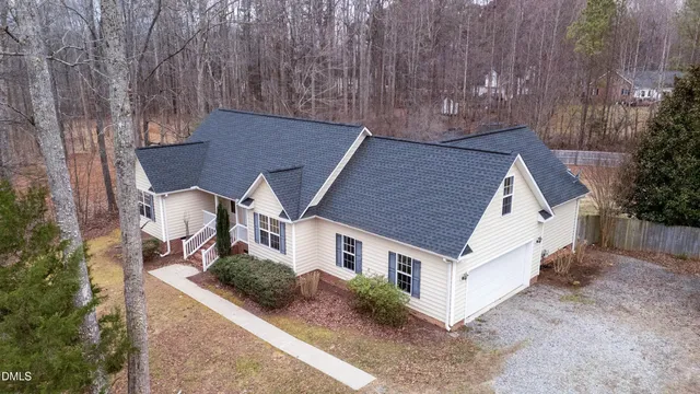 a aerial view of a house with a yard and large tree