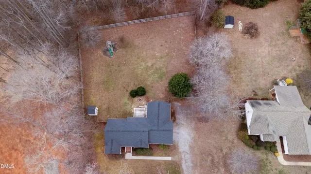 an aerial view of a house with a yard and a wooden wall