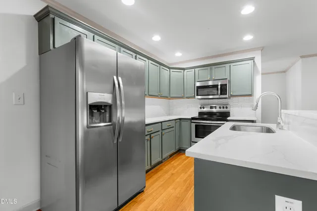 a kitchen with a refrigerator sink and stainless steel appliances
