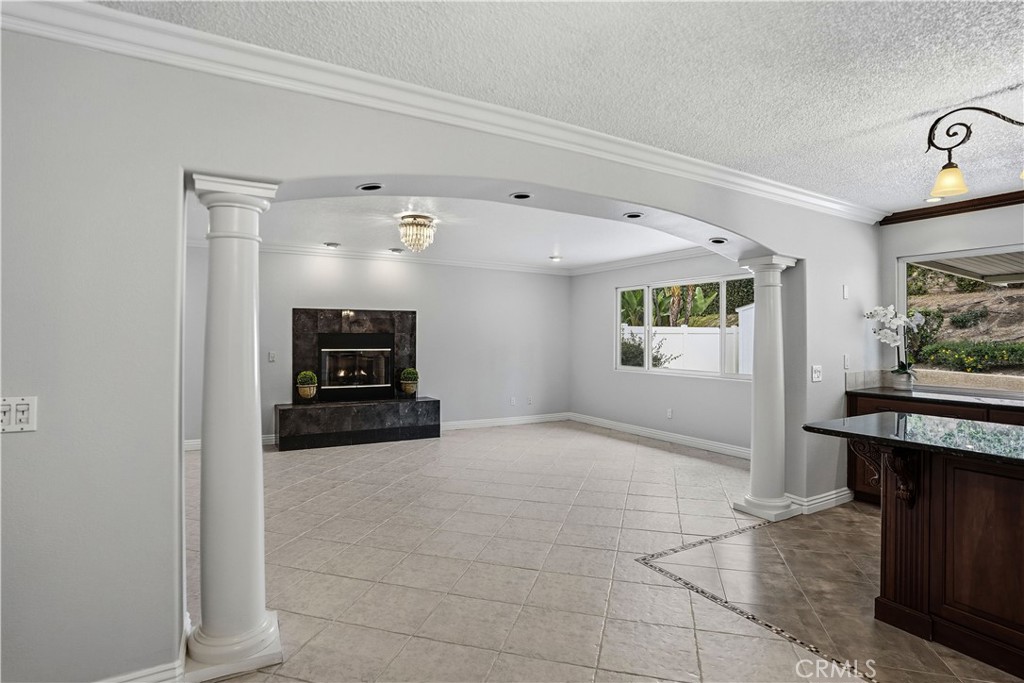 6568 Balzac Circle Riverside, CA 92506 - Photo 18 of 62 Kitchen leading into the added on family room with gas fireplace. Roman pillar colums make a dramatic entry.