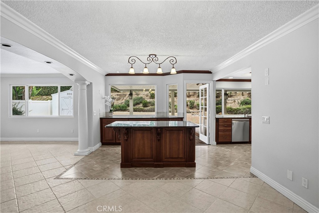 6568 Balzac Circle Riverside, CA 92506 - Photo 20 of 62 Show stopper kitchen! Designed for entertaining! Complete with granite island, custom lights above. Tons of windows and counter buffet space was added. Door to the alumawood patio and pool area. Custom travertine floor pattern was built to accentuate your stunning kitchen!