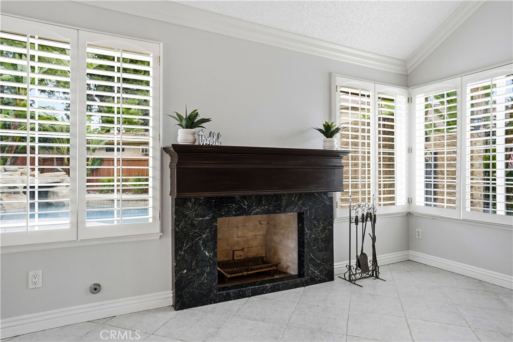 6568 Balzac Circle Riverside, CA 92506 - Photo 25 of 62 Living room gas fireplace is surrounded by windows to view your outdoor salt water pool, jacuzzi, firepit area! Plantation shutters over the windows.