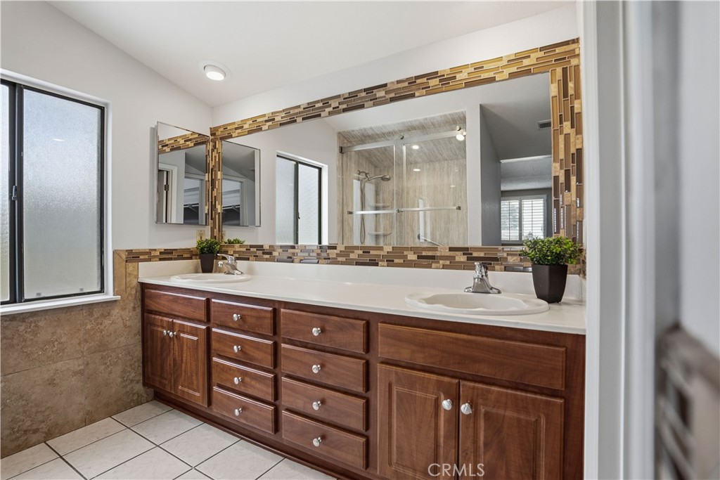 6568 Balzac Circle Riverside, CA 92506 - Photo 37 of 62 Primary bathroom upstairs has dual sinks with custom travertine surrounding the mirror and walls. All tiled bathroom flooring.