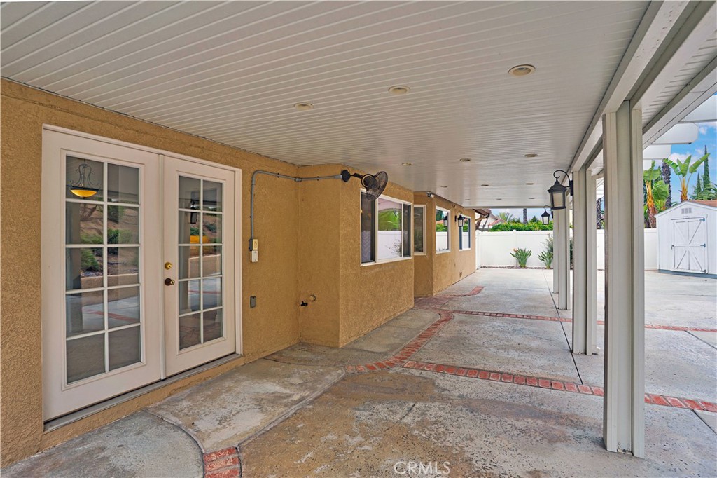 6568 Balzac Circle Riverside, CA 92506 - Photo 41 of 62 2 doors are under the alumawood patio to the back yard. One from the kitchen, and double french doors from the living room. Alumawood patio has recessed lighting, ustom lights and ceiling fan. Stamped concrete makes it easy to clean. Shed in the corner will stay.