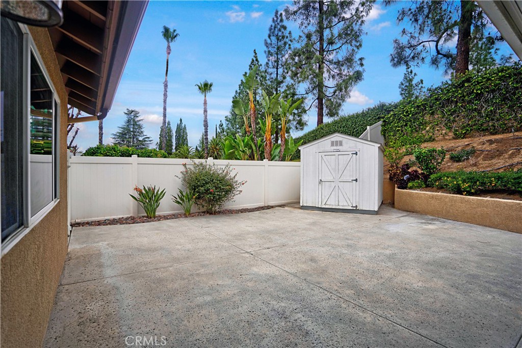 6568 Balzac Circle Riverside, CA 92506 - Photo 42 of 62 Stamped concret back yard is trimmed with landscaping and built-in shed that will stay.