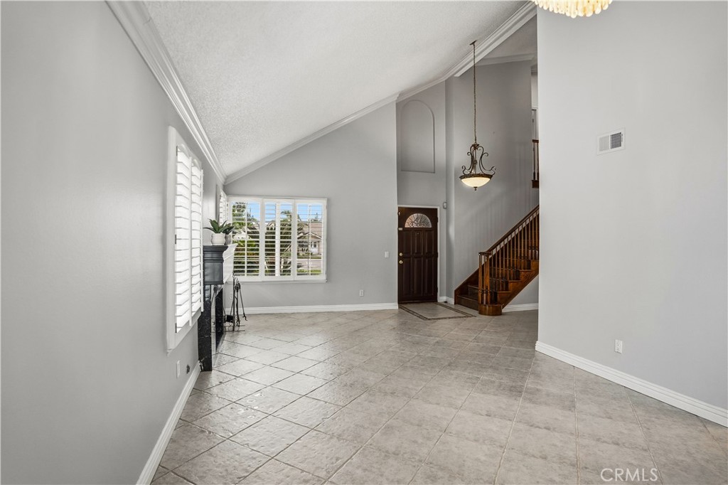 6568 Balzac Circle Riverside, CA 92506 - Photo 8 of 62 Living room with staircase greets you. Gas fireplace. Chandelier above your dining room space. Windows all have plantation shutters.