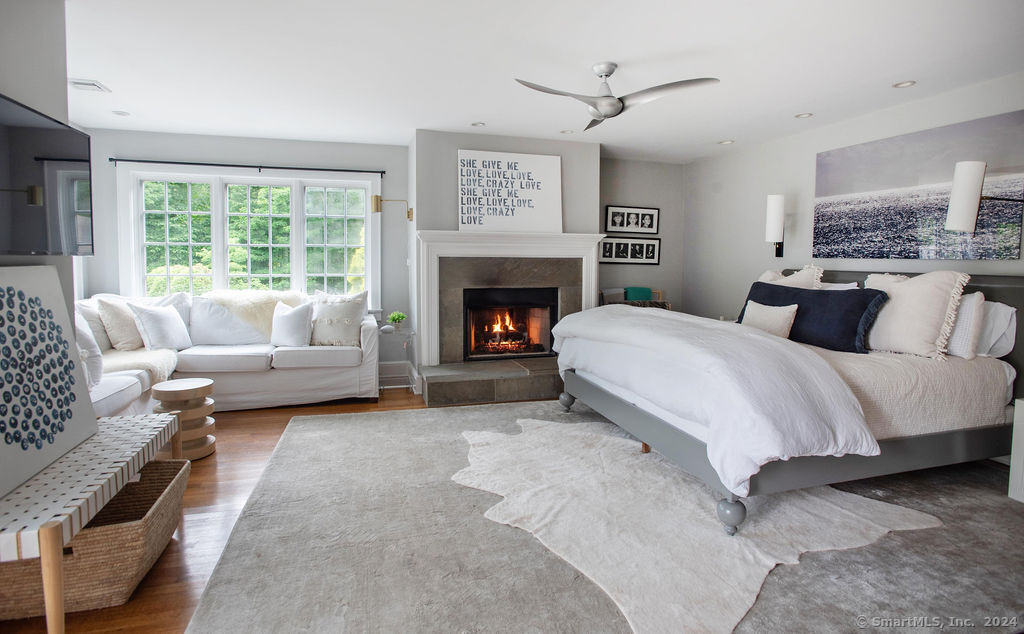 474 Brookside Road Norwalk, CT 06850 - Photo 18 of 40 a spacious bedroom with a bed a couch and a fireplace