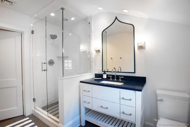 a bathroom with a double vanity sink mirror and shower