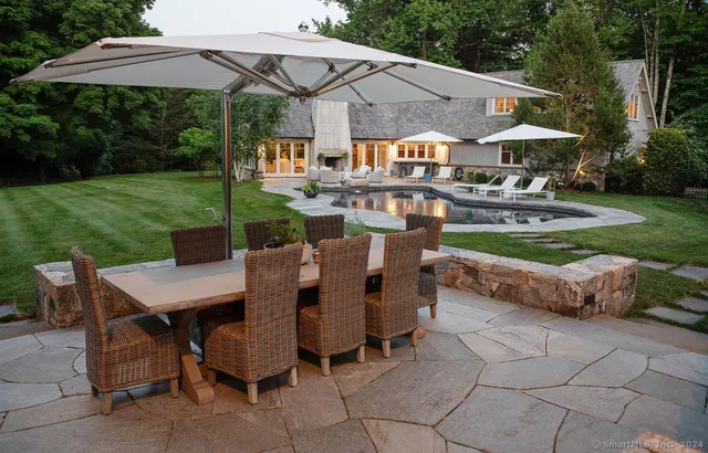 a view of a patio with table and chairs under an umbrella
