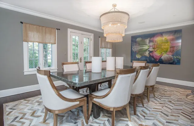 a view of a dining room with furniture a chandelier and wooden floor