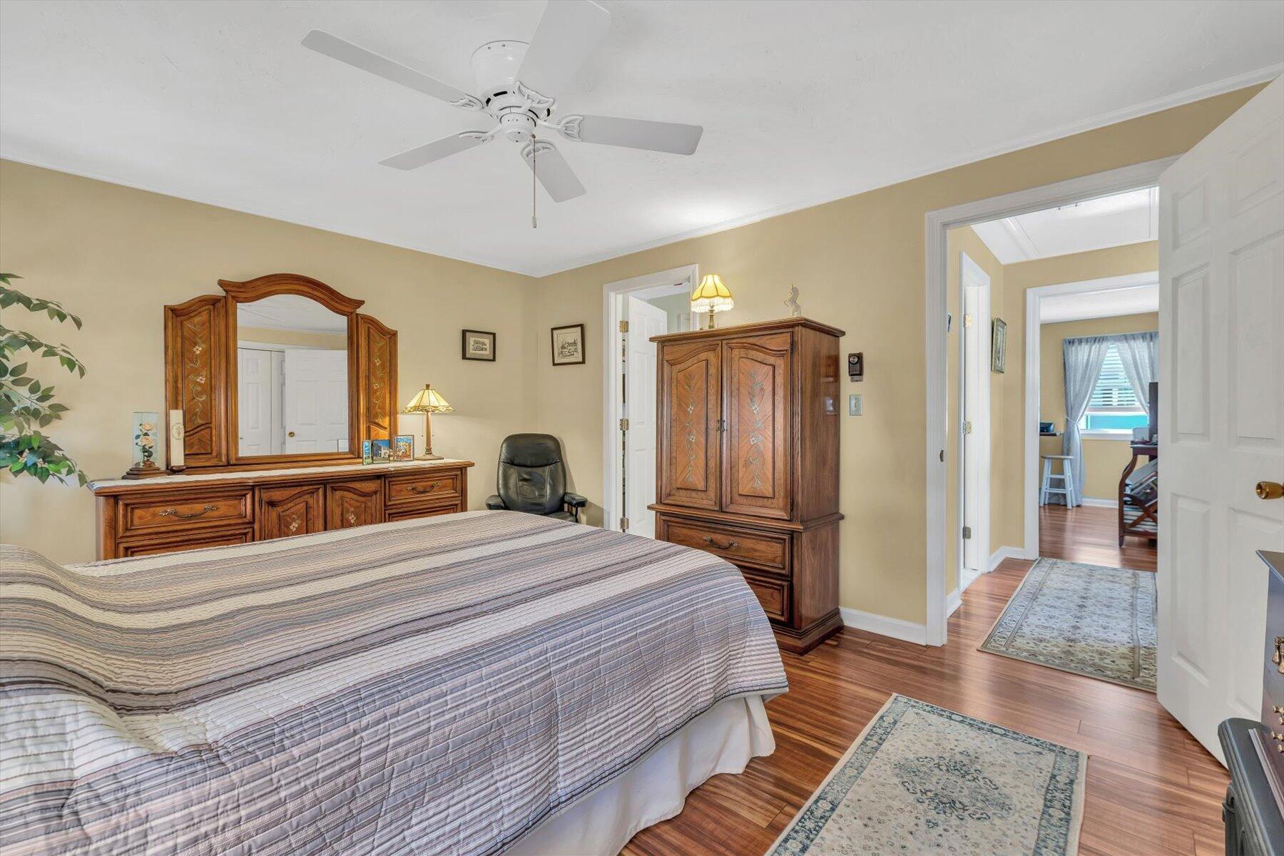 441 Buck Island Road, Unit B1 West Yarmouth, MA 02673 - Photo 19 of 31 a bedroom with a large bed a chandelier with dresser and mirror