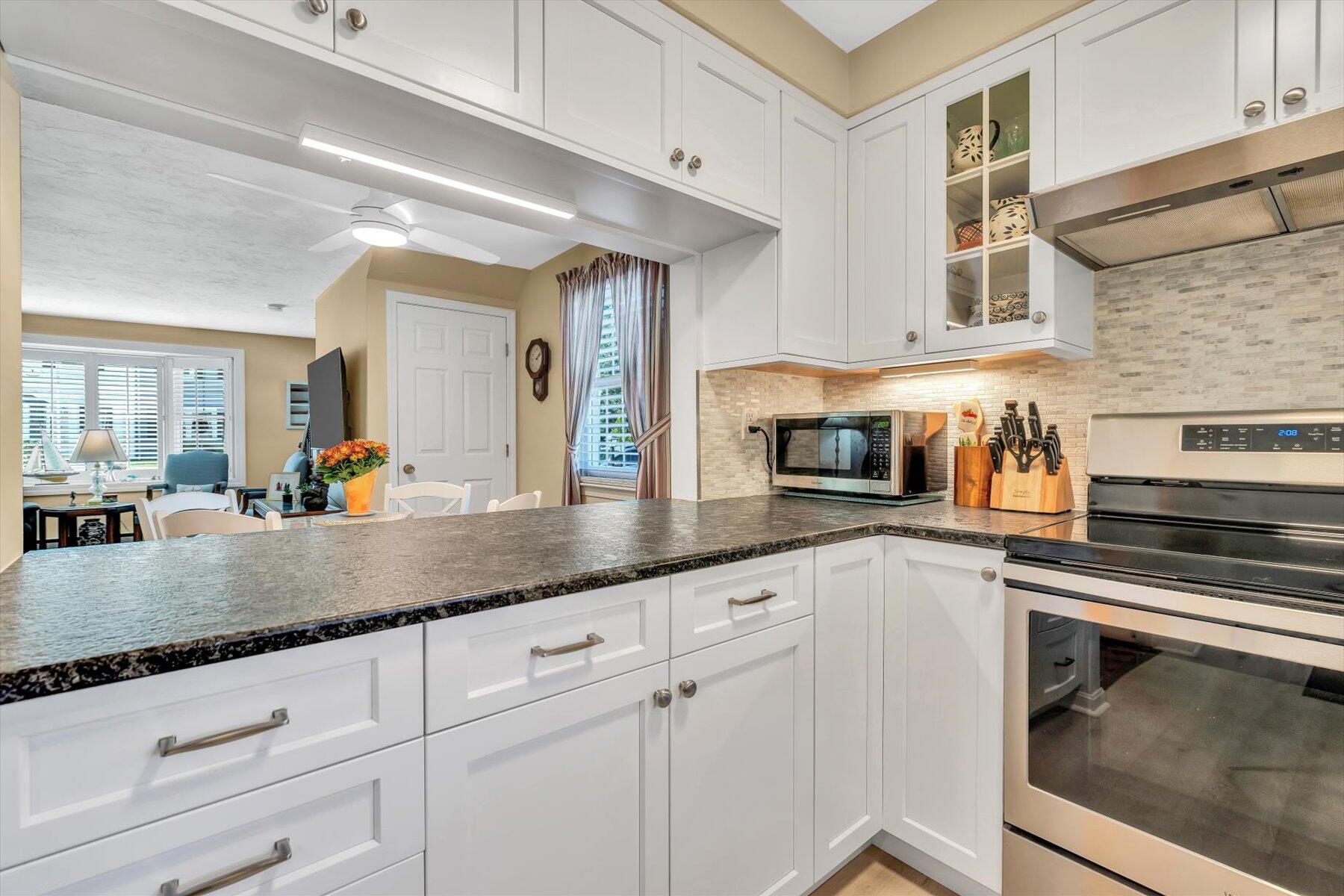 441 Buck Island Road, Unit B1 West Yarmouth, MA 02673 - Photo 5 of 31 a kitchen with granite countertop white cabinets and stainless steel appliances