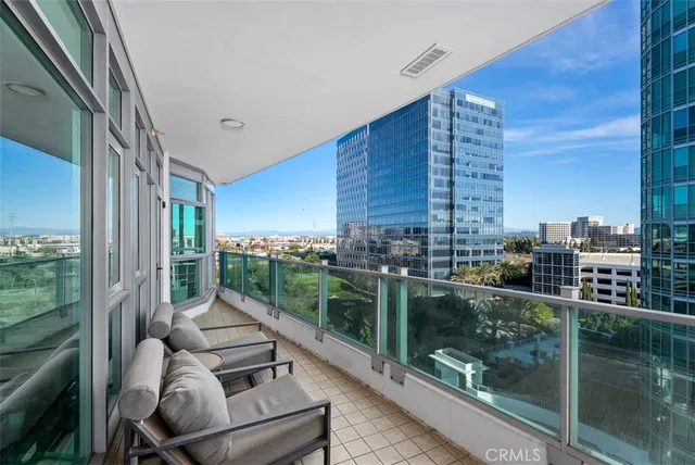 a view of a balcony with couches with wooden floor and fence