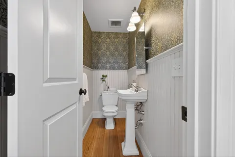 a bathroom with a toilet a sink and a mirror