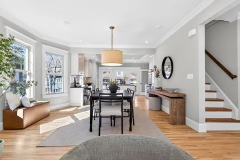 a kitchen with stainless steel appliances granite countertop a refrigerator a sink dishwasher a stove and white cabinets with wooden floor