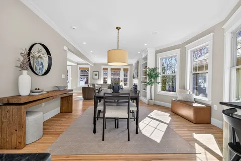 a kitchen with stainless steel appliances granite countertop a refrigerator a stove top oven a sink dishwasher and white cabinets with wooden floor