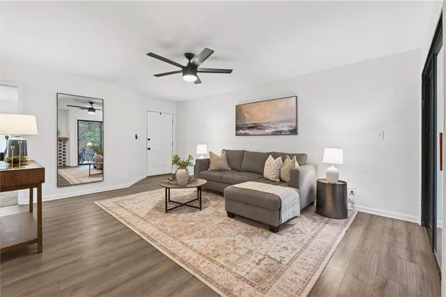 a living room with furniture and a view of kitchen