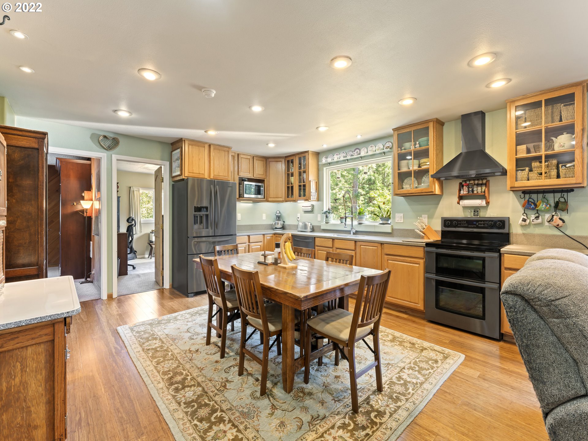 3530 Highway 38 Drain, OR 97435 - Photo 6 of 32 a kitchen with stainless steel appliances kitchen island granite countertop a refrigerator a stove a sink a dining table and chairs with wooden floor