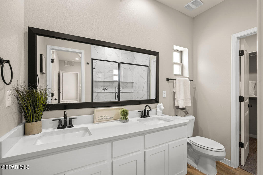 664 Paseo Musical Street El Paso, TX 79928 - Photo 34 of 50 a bathroom with a double vanity sink toilet and a mirror