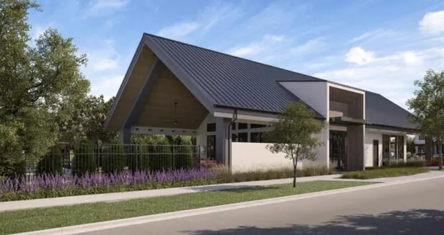 a front view of a house with a garden and plants