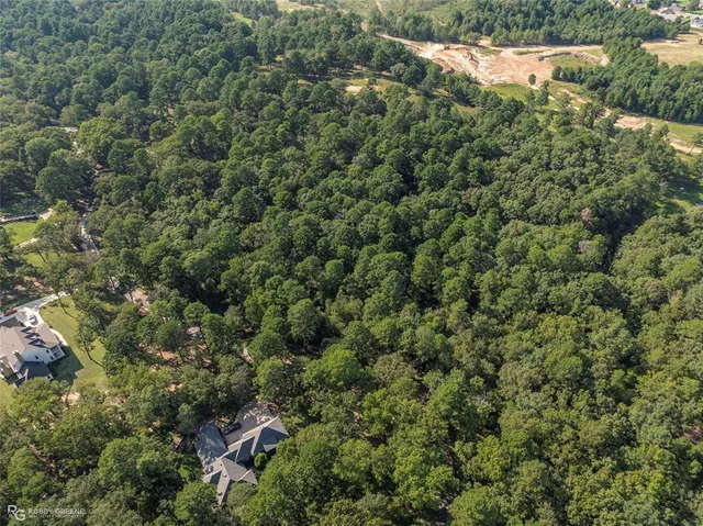 an aerial view of residential house with outdoor space and trees all around