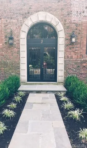 a view of a brick house with potted plants