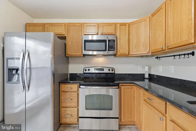 a kitchen with stainless steel appliances granite countertop a stove a refrigerator and a microwave