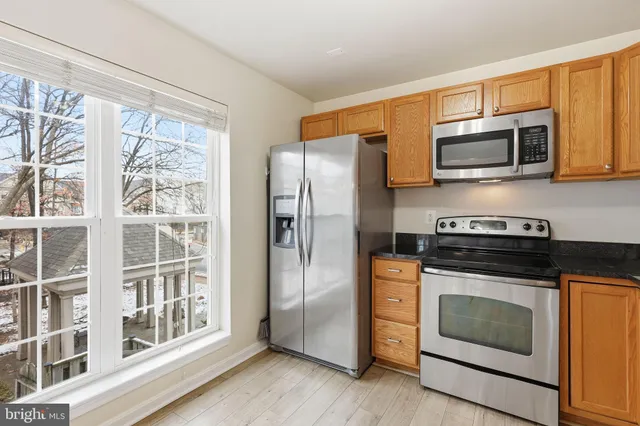 a kitchen with stainless steel appliances granite countertop a stove a microwave and a refrigerator