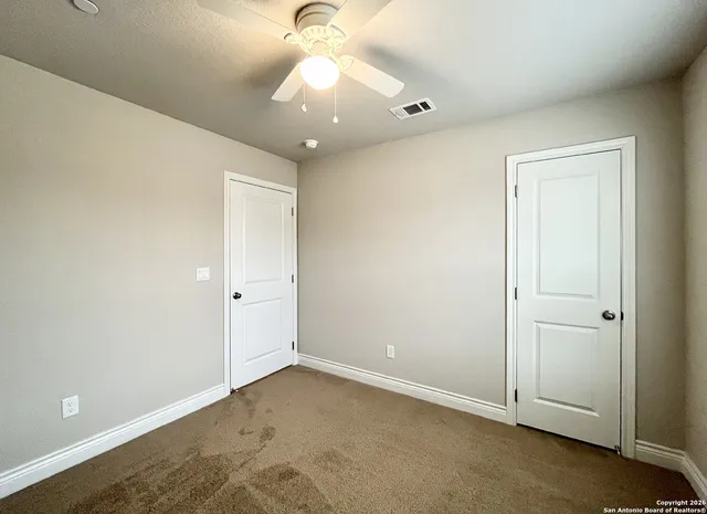 an empty room with a ceiling fan and a window