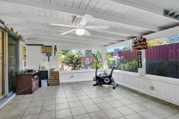 an empty room with wooden floor and ceiling fan