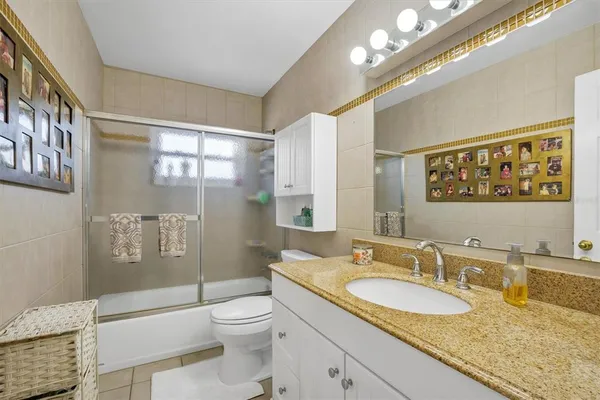 a bathroom with a sink a toilet and a large mirror