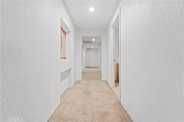a view of a hallway with wooden floor and a bathroom