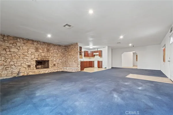 a view of an empty room with a fireplace and a window