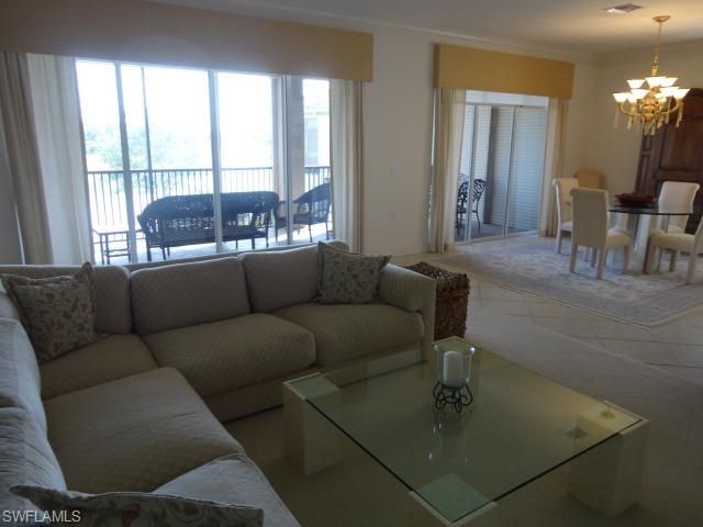 755 Regency Reserve Circle, Unit 5004 Naples, FL 34119 - Photo 11 of 24 a living room with furniture and a large window
