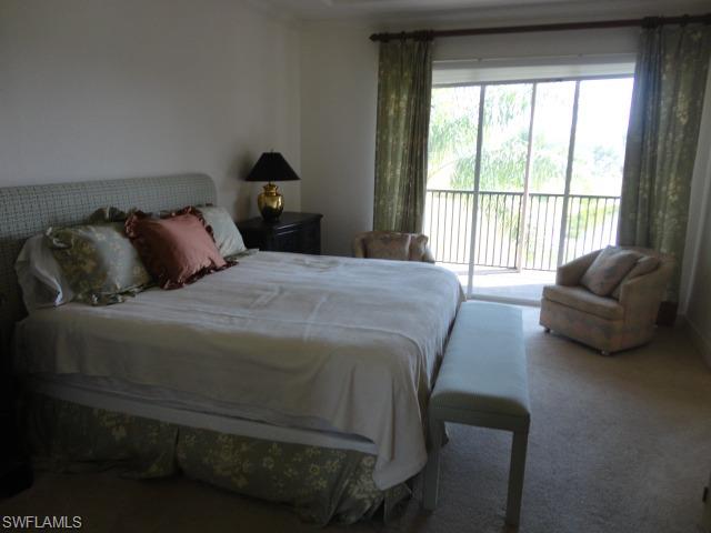 755 Regency Reserve Circle, Unit 5004 Naples, FL 34119 - Photo 14 of 24 a bedroom with a bed couch and a large window