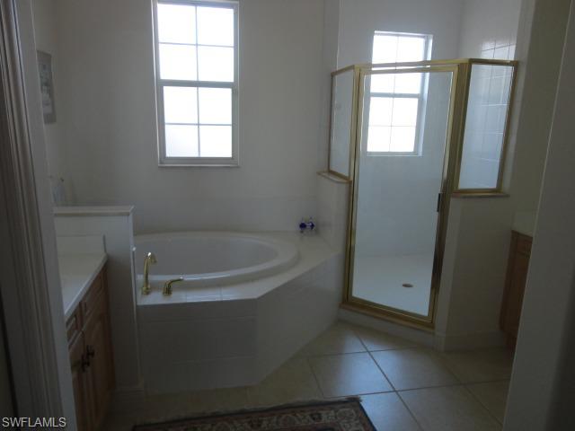 755 Regency Reserve Circle, Unit 5004 Naples, FL 34119 - Photo 16 of 24 a bathroom with bathtub and window