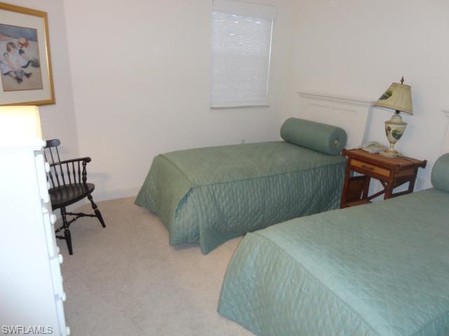 755 Regency Reserve Circle, Unit 5004 Naples, FL 34119 - Photo 20 of 24 a bedroom with a bed and wooden floor