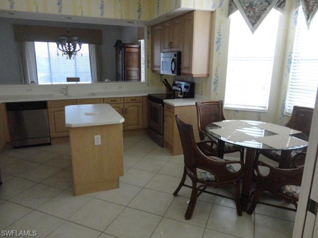 755 Regency Reserve Circle, Unit 5004 Naples, FL 34119 - Photo 5 of 24 a dining room with a sink a counter top space and a window