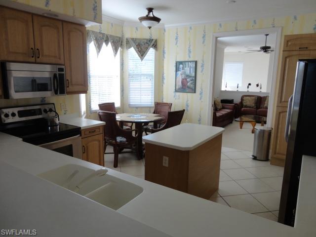755 Regency Reserve Circle, Unit 5004 Naples, FL 34119 - Photo 7 of 24 a kitchen with a sink a counter top space and stainless steel appliances