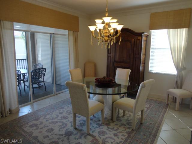 755 Regency Reserve Circle, Unit 5004 Naples, FL 34119 - Photo 8 of 24 a dining room with furniture a chandelier and window