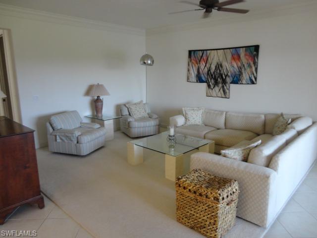 755 Regency Reserve Circle, Unit 5004 Naples, FL 34119 - Photo 9 of 24 a living room with furniture and painting on the wall