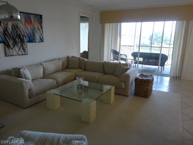 755 Regency Reserve Circle, Unit 5004 Naples, FL 34119 - Photo 10 of 24 a living room with furniture and a large window