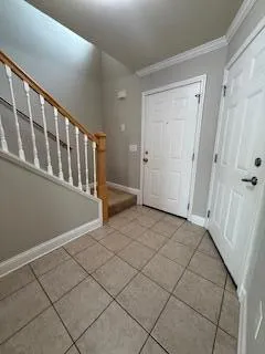 a view of an empty room with wooden staircase