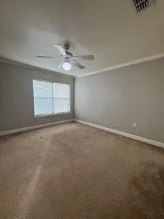 an empty room with a window and a fan