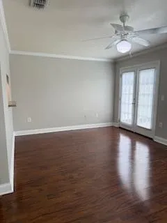 a view of an empty room with window and wooden floor
