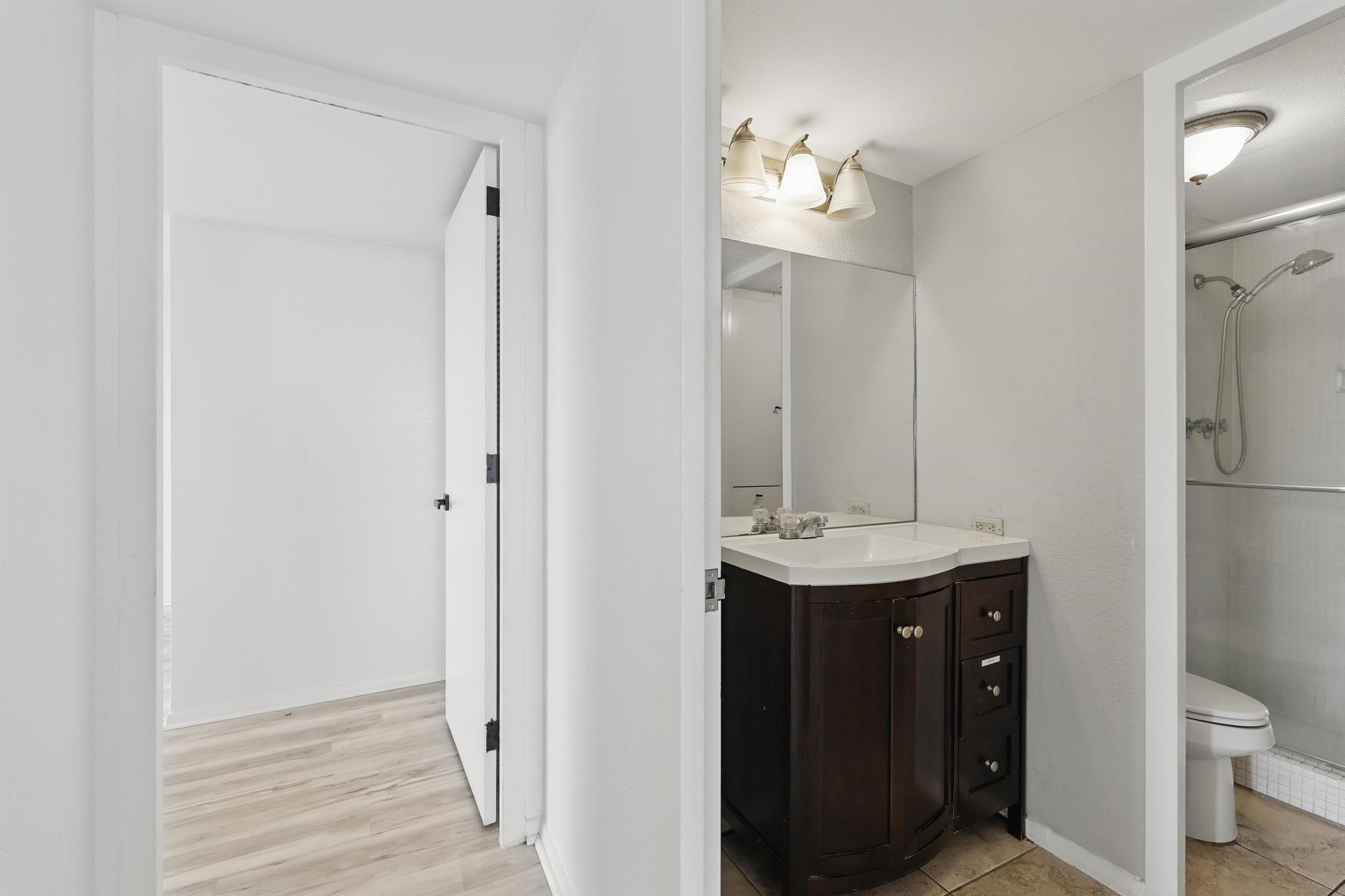 2016 Main Street, Unit 1502 Houston, TX 77002 - Photo 15 of 20 a bathroom with a sink a toilet and shower