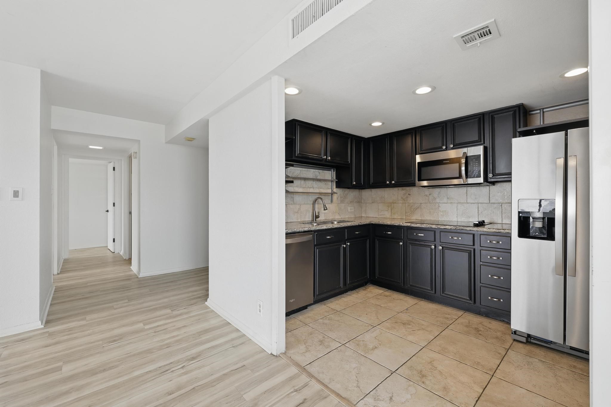 2016 Main Street, Unit 1502 Houston, TX 77002 - Photo 3 of 20 a kitchen with stainless steel appliances granite countertop a refrigerator and a stove top oven